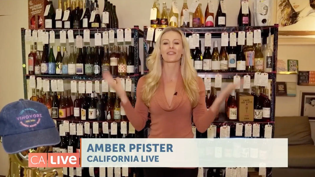 A clip of newswoman Amber Pfister (blond woman in front of a wall of wine bottles)
