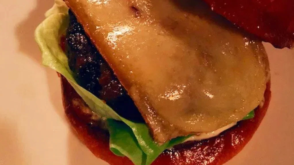 Very closeup shot of an open-face cheeseburger