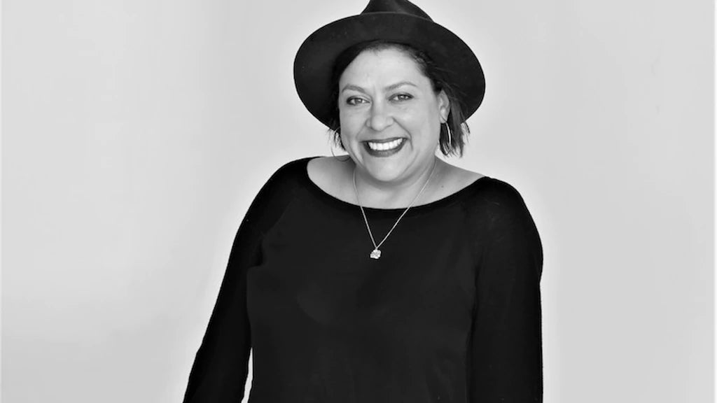 Studio portrait of Vinovore owner Coly Den Haan wearing a black hat and shirt (shot in black and white)