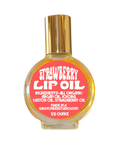 Bottle of strawberry lip oil with a gold cap on a white background