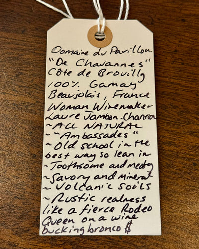 Handwritten wine label on a wooden surface