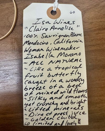 Handwritten wine label on a wooden surface