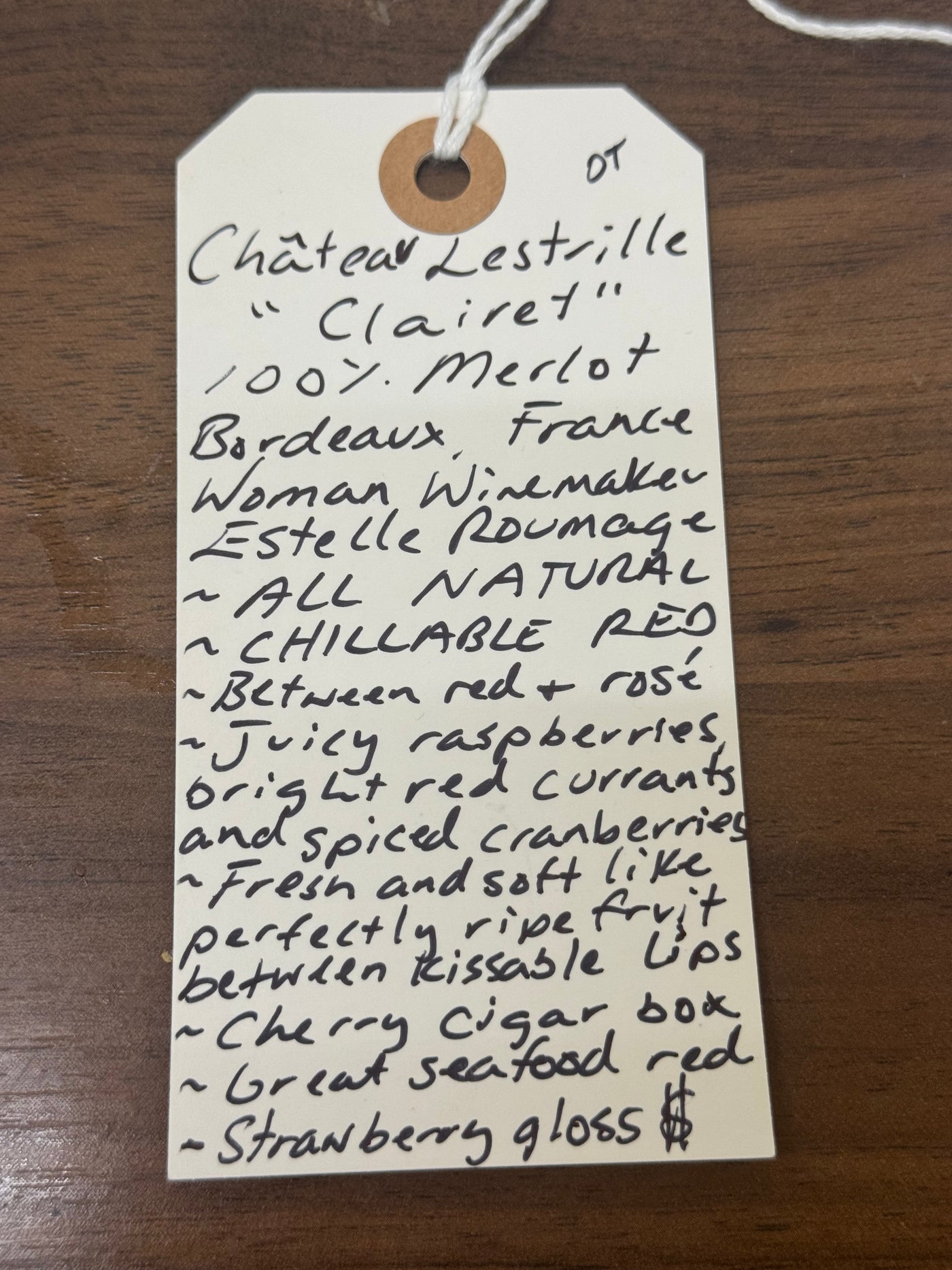 Handwritten wine label on a wooden surface
