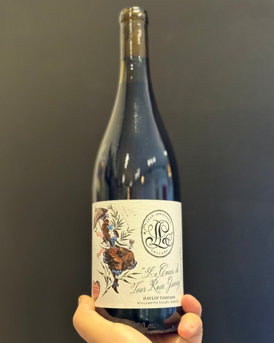 Bottle of wine held against a dark background