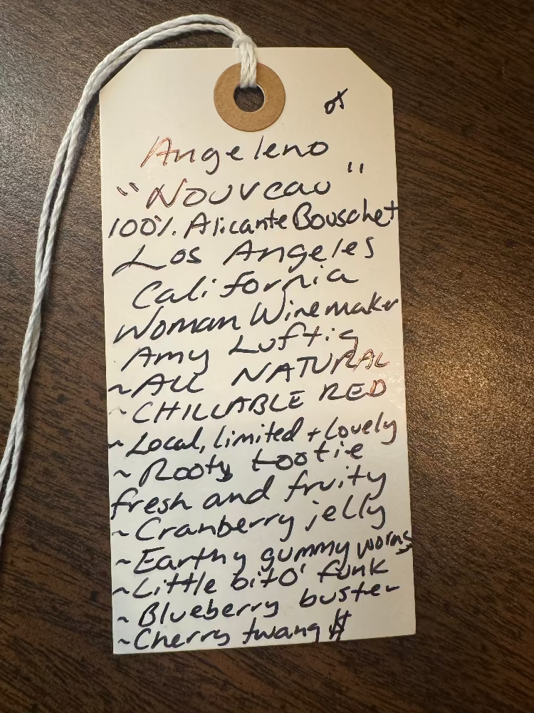 Handwritten wine label on a wooden surface