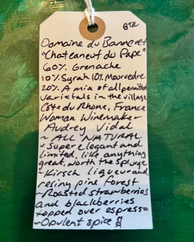 Handwritten wine label on a textured green background