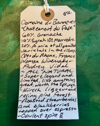 Handwritten wine label on a textured green background