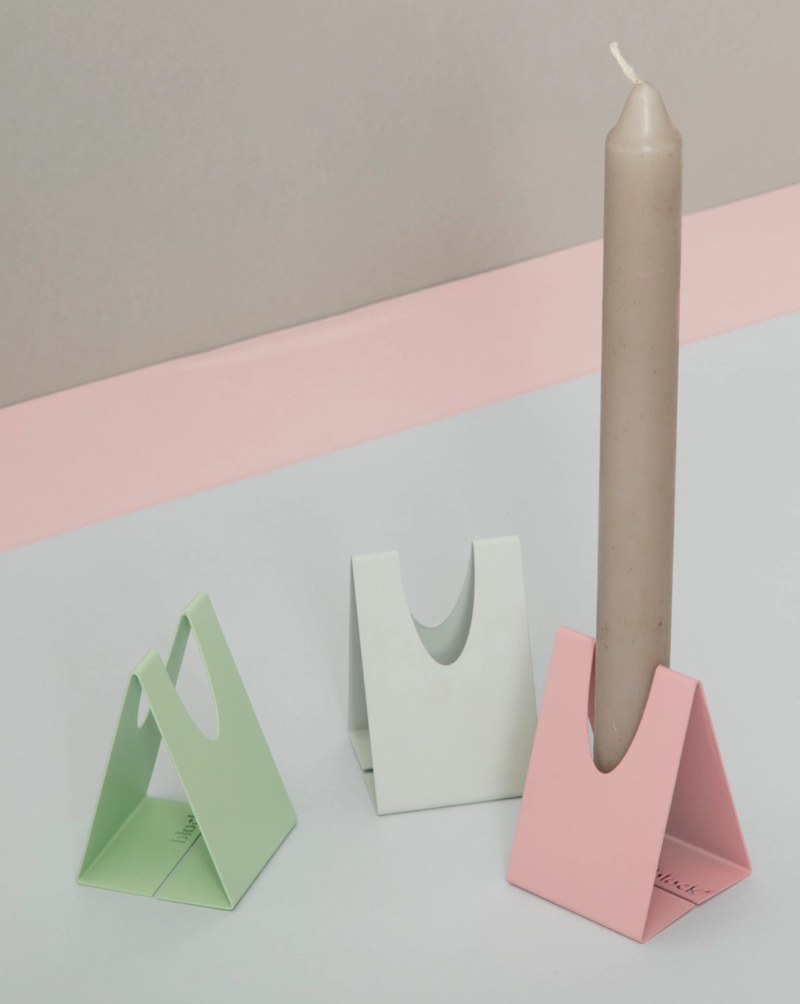 An innovative candlestick holder crafted from a single piece of folded steel. An elegant addition to the dining table. The unique design encourages creativity with your display, whilst keeping candles securely in place. The candlestick holder's muted colour palette complements a range of candle colours, from vibrant brights to soft pastels.