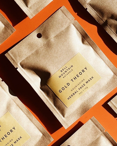 Herbal face mask packaging with 'Gold Theory' label on a textured surface.