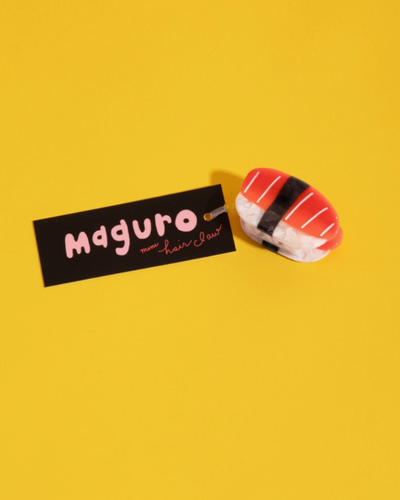 Sushi-shaped hair clip with 'Maguro' label on a yellow background