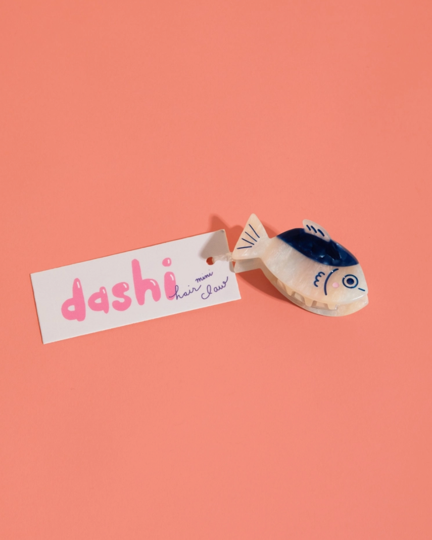 Small fish-shaped toy with 'dashi' label on a pink background