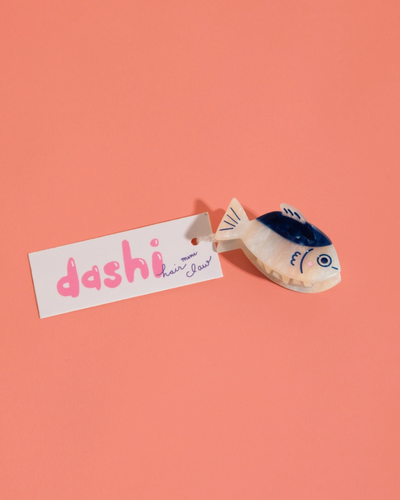 Small fish-shaped toy with 'dashi' label on a pink background
