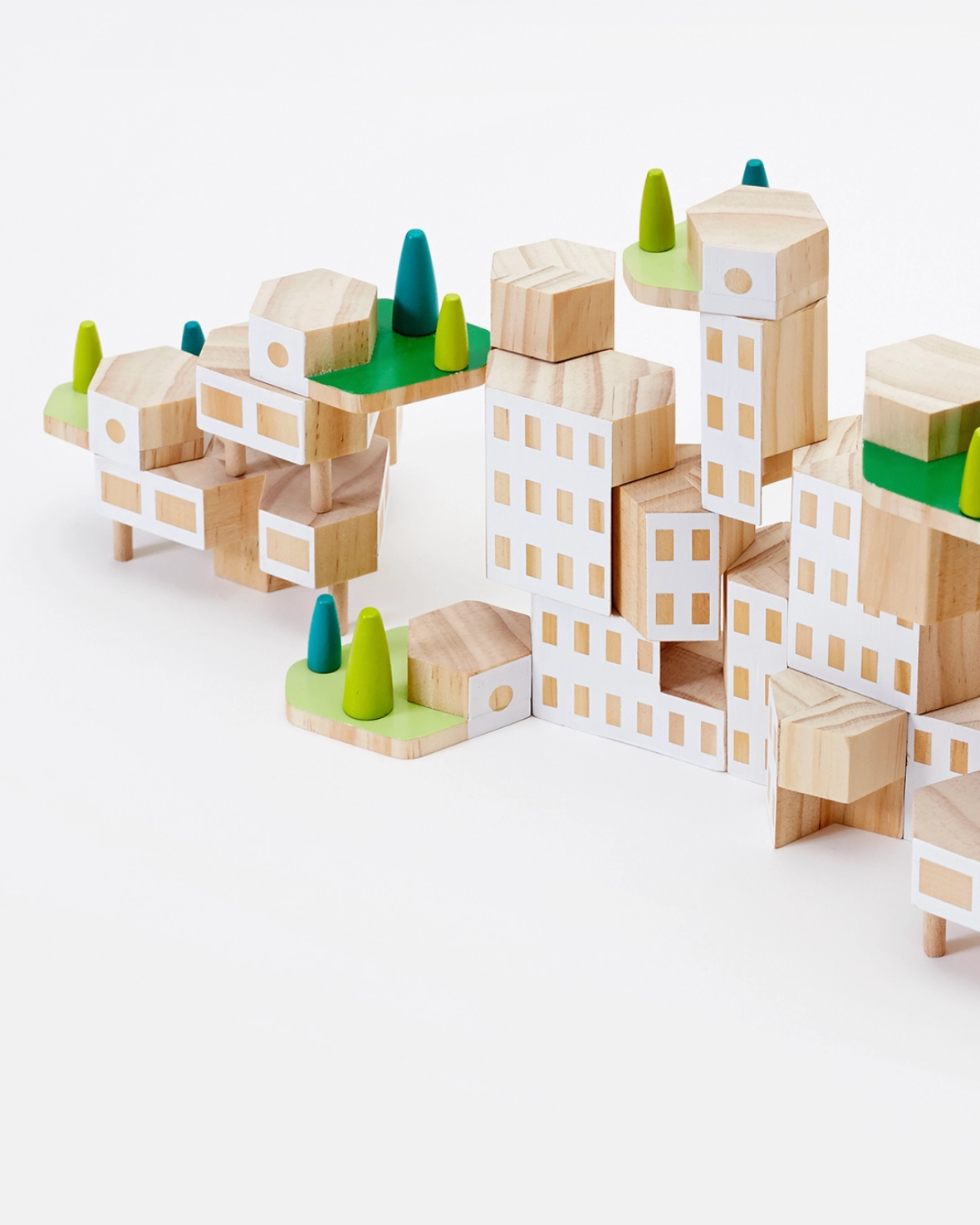 Wooden block toy city with green trees on a white background