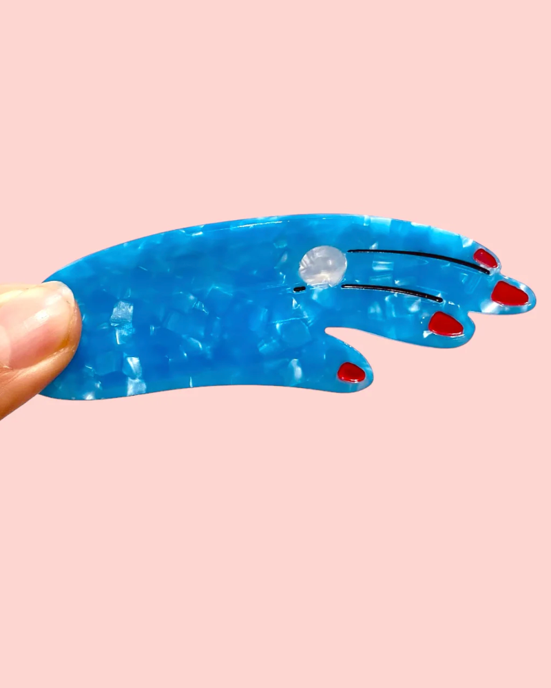 Blue plastic tool with red handles on a pink background