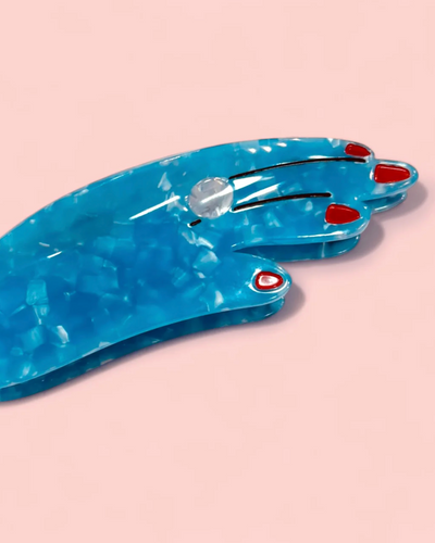 Blue shoe with red heart designs on a pink background