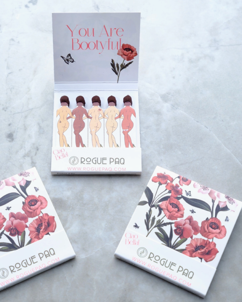 Three boxes of Rogue Pao products on a marble surface, with one box featuring a humorous design.