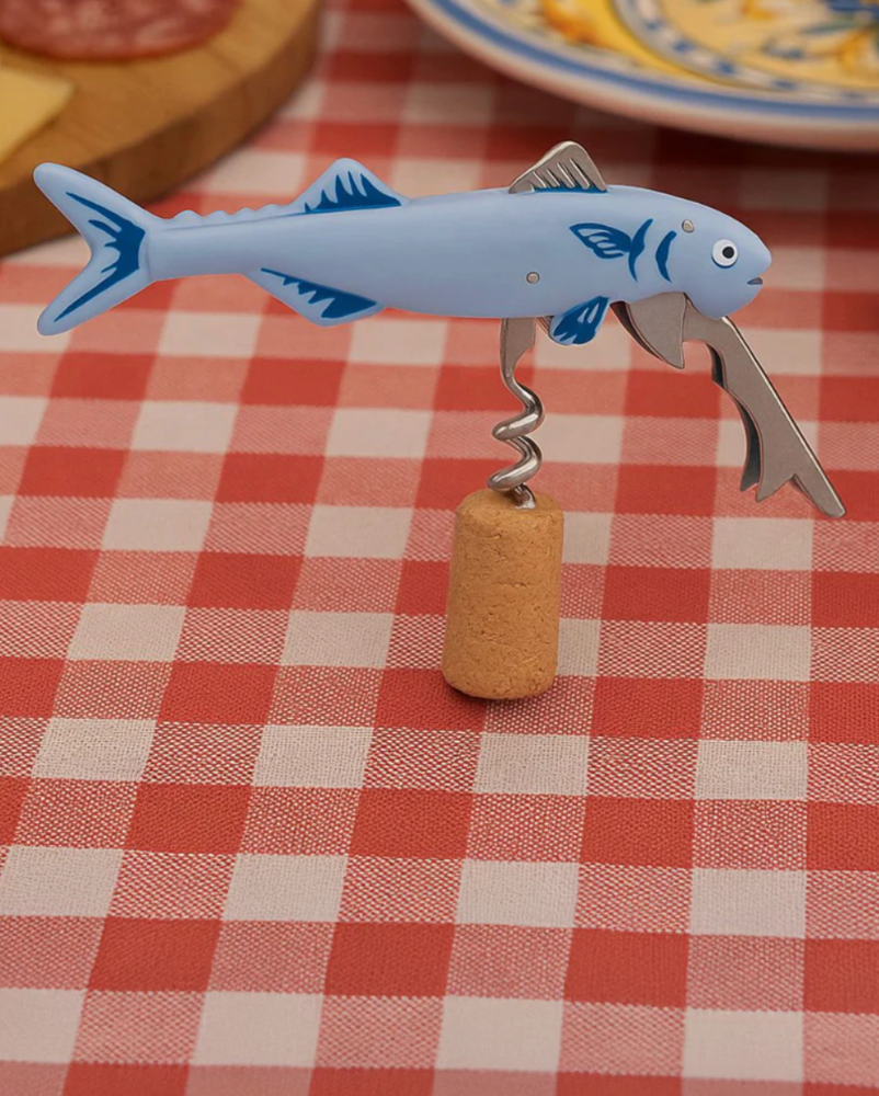Fish-shaped bottle opener with cork on a red and white checkered tablecloth