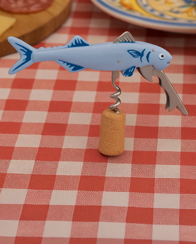 Fish-shaped bottle opener with cork on a red and white checkered tablecloth