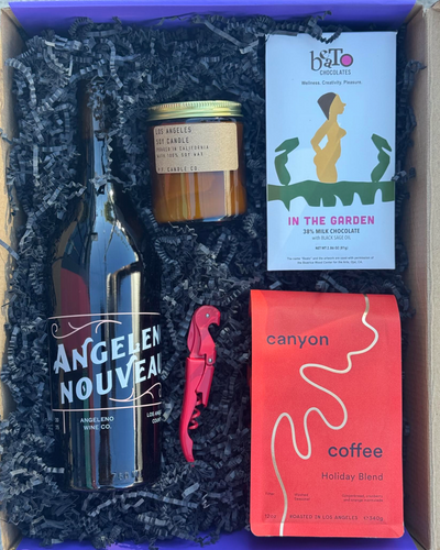 Gift box with various items including a bottle, candle, and coffee package.