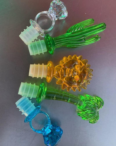 Assorted acrylic wine stoppers. Pick your faves! Bling ring in blue or clear, green palm tree or cactus, orange sun. Sold individually.