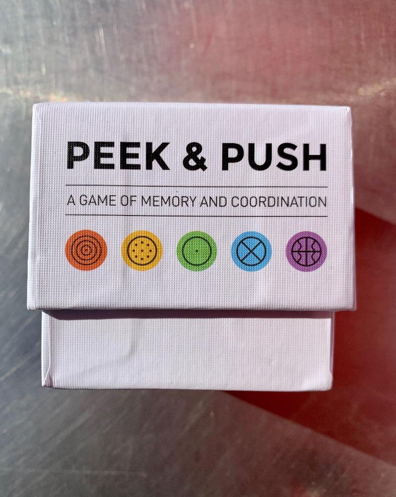 PEEK & PUSH is a 2-player strategy game that puts your memory to the test. Create a set or run before your opponent does, and you win! The game begins with all of the tiles face down. Peek to see the contents of a tile, or Push a row or column to shift the board. But be careful, don't lose track of tiles you’ve already uncovered! It’s your move, will you Peek or Push? - Varying levels of difficulty from beginner to advanced. - Up to 2 players, 5-minute gameplay, & ages 10+.